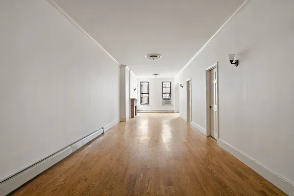 a living room with stainless steel appliances kitchen island granite countertop furniture and a wooden floor