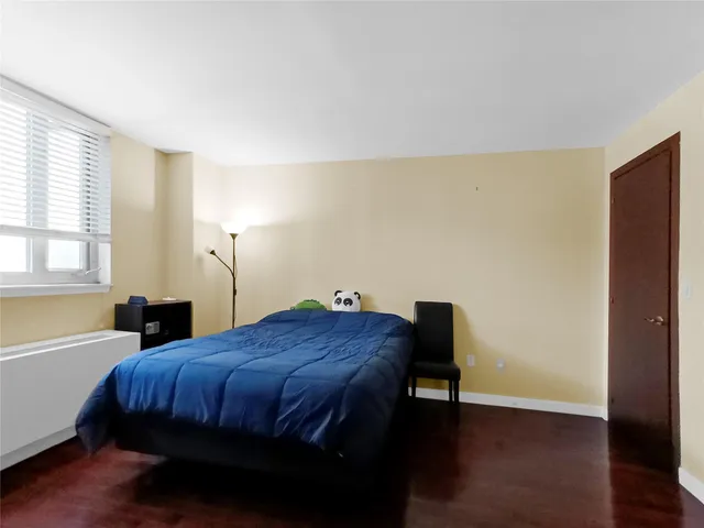 a bed sitting in a bedroom next to a window and a chair