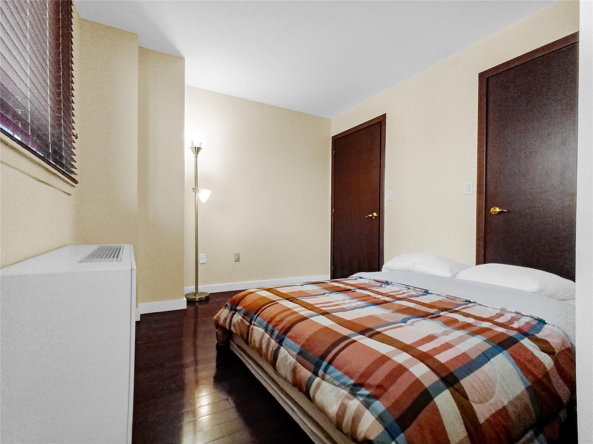 133-38 Sanford Avenue, Unit 6A Queens, NY 11355 - Photo 12 of 22 a bedroom with a bed and wooden floor