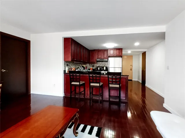 a kitchen with stainless steel appliances wooden floors and wooden cabinets
