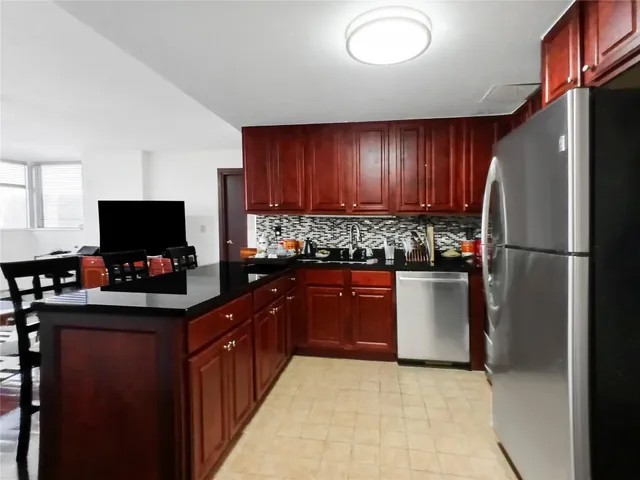 a kitchen with stainless steel appliances granite countertop a refrigerator and a stove top oven