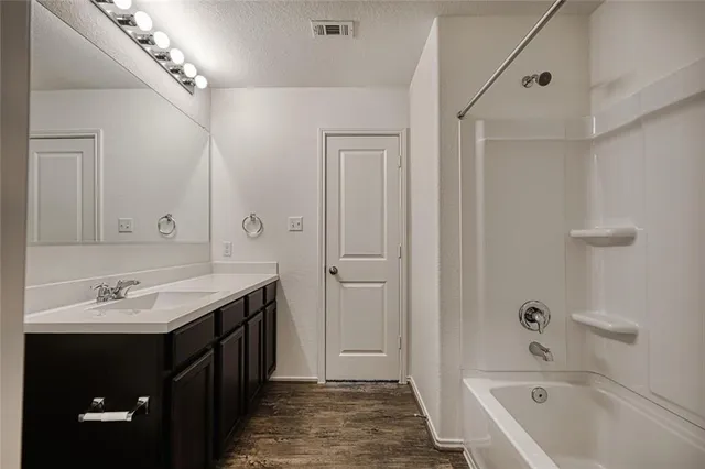 a bathroom with a tub a sink and mirrors