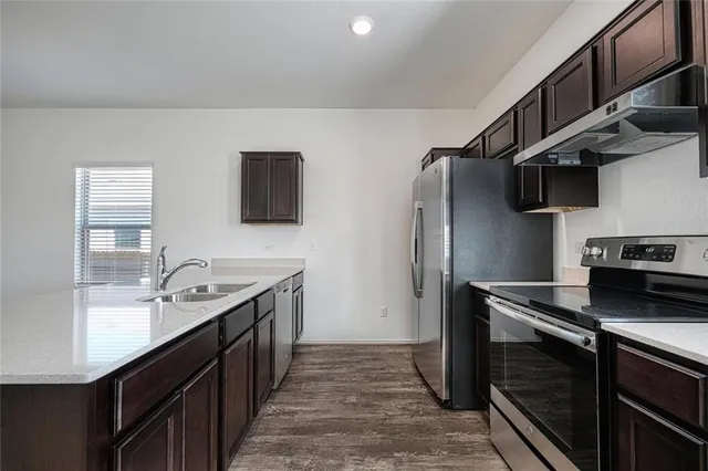 a kitchen with stainless steel appliances granite countertop a sink stove and refrigerator