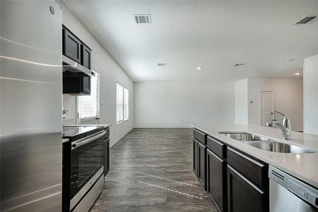 a kitchen with granite countertop a stove and a sink