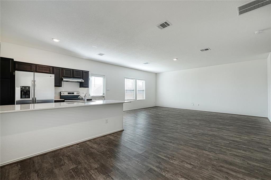 772 Circle Way Jarrell, TX 76537 - Photo 8 of 20 a large kitchen with stainless steel appliances a large counter top a stove and a wooden floors
