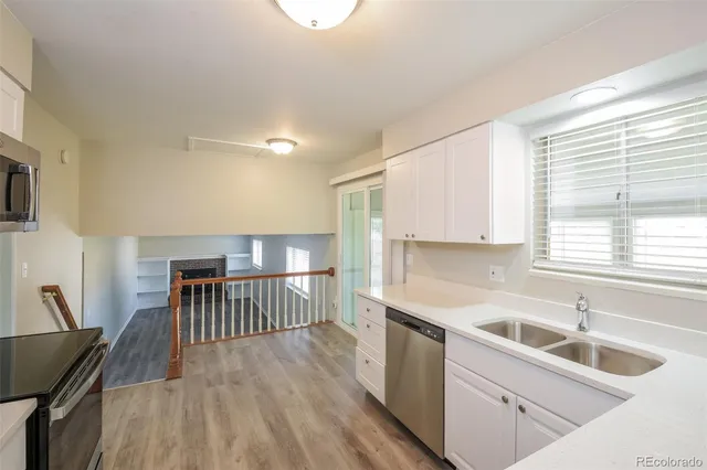 a kitchen that has a sink a table and chairs in it