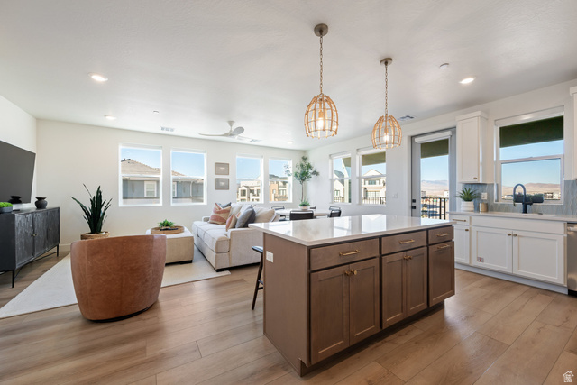 762 West Periwinkle Lane, Unit 102 St. George, UT 84790 - Photo 38 of 40 Kitchen featuring open floor plan, a center island, light wood-style floors, a breakfast bar, and two tone cabinets