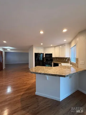 a view of kitchen with stainless steel appliances granite countertop a large counter top and a stove
