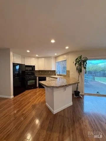 a view of kitchen with refrigerator microwave and wooden floor