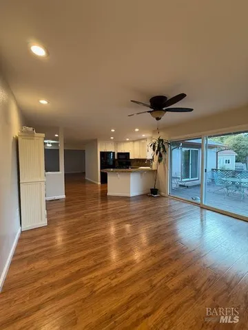 a view of a living room a kitchen and a wooden floor