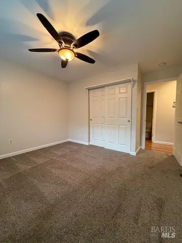 a view of a livingroom with a ceiling fan and window