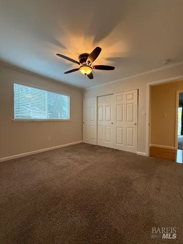 a view of a livingroom with a ceiling fan and window