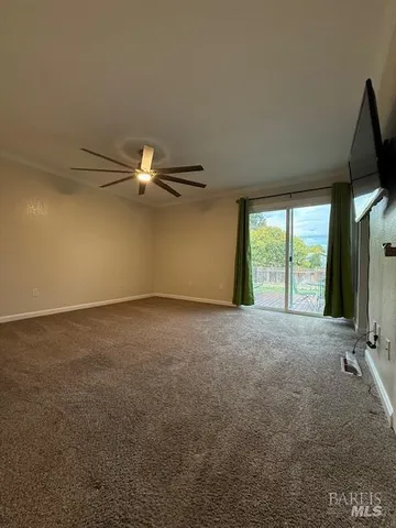 a view of a livingroom with a ceiling fan and window