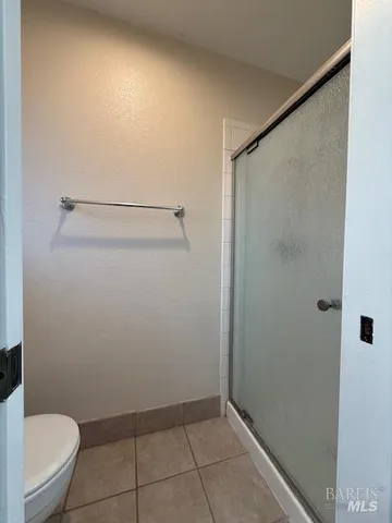 a bathroom with a granite countertop toilet and a shower