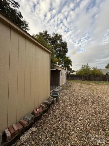 a view of a dry yard with wooden fence