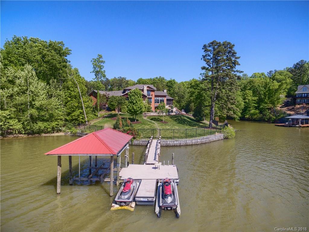 2649 River Ridge Place Fort Mill, SC 29708 - Photo 32 of 34 a view of a lake with table and chairs under an umbrella