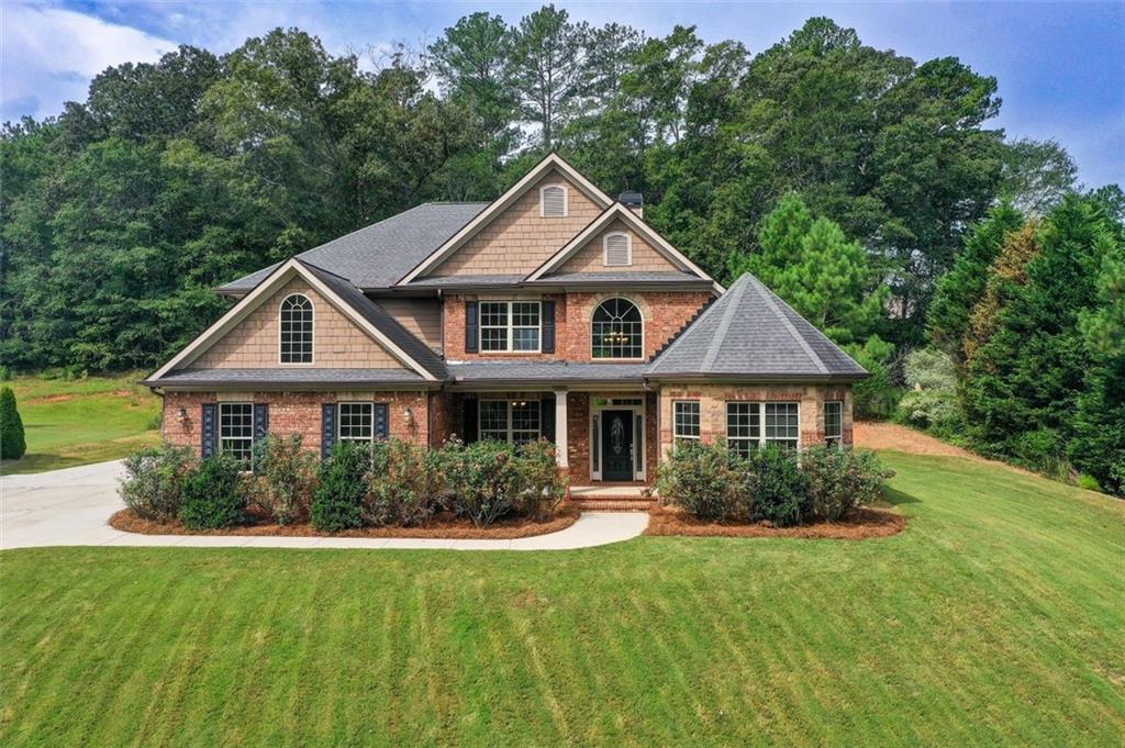 a front view of a house with a yard and trees