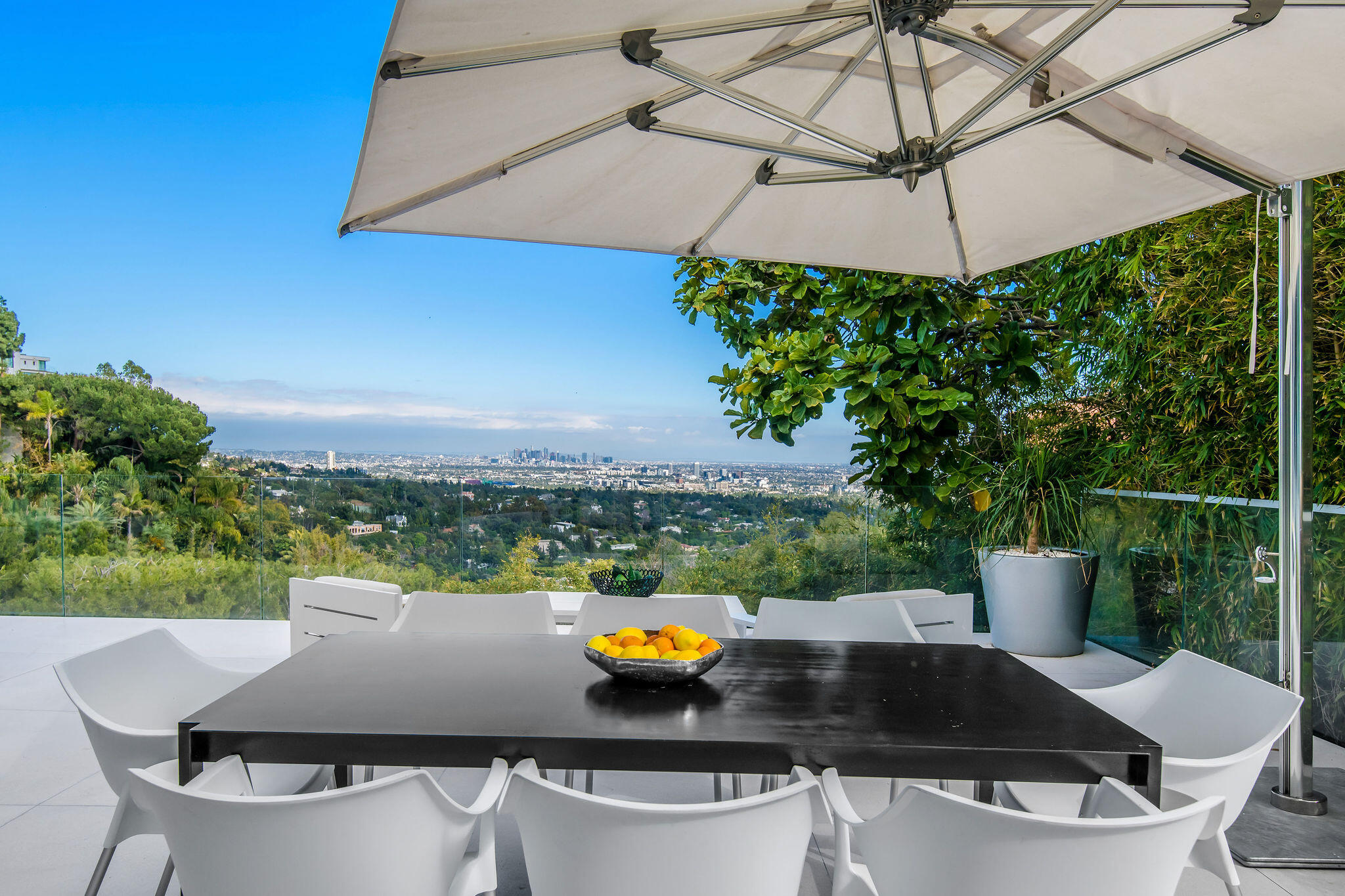 1288 Angelo Drive Beverly Hills, CA 90210 - Photo 28 of 33 a view of a patio with furniture and a umbrella