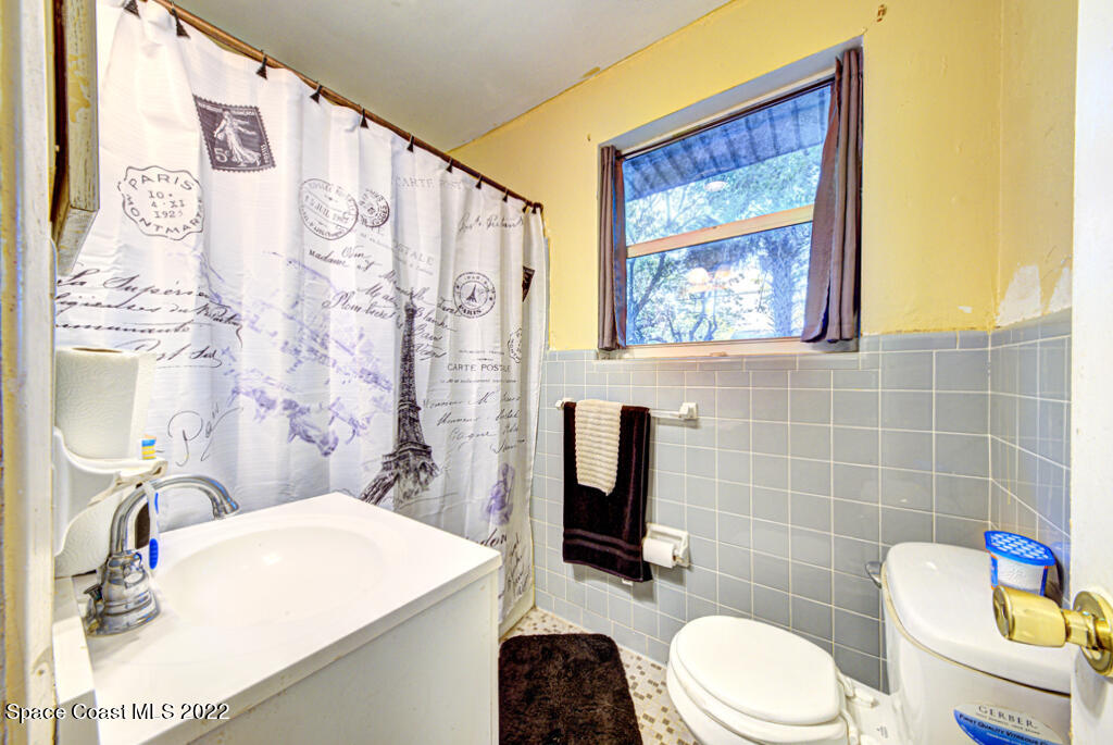 1210 Princeton Road Cocoa, FL 32922 - Photo 21 of 37 a bathroom with a toilet a sink and a shower curtain