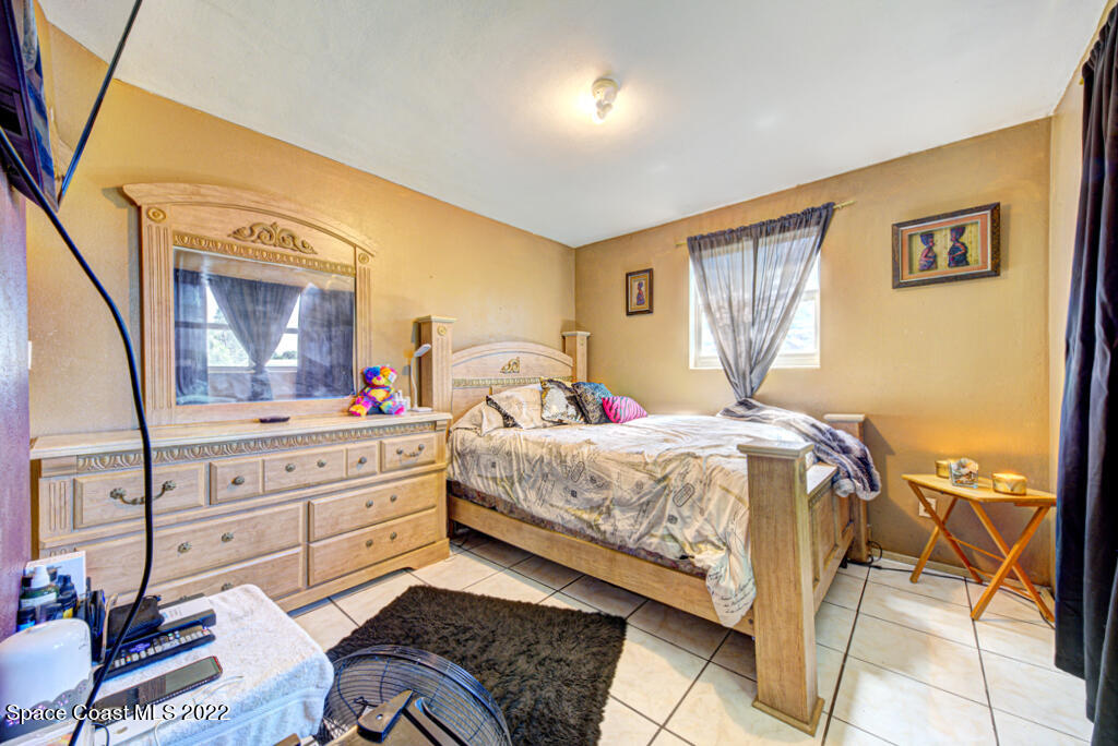1210 Princeton Road Cocoa, FL 32922 - Photo 24 of 37 a bedroom with a bed and a mirror on the dresser