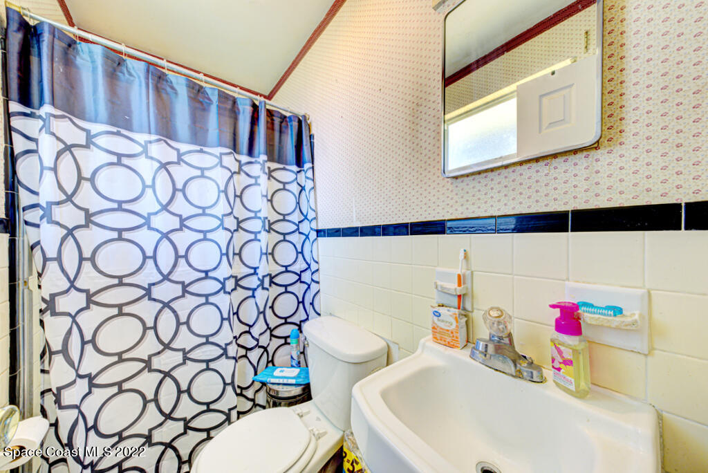 1210 Princeton Road Cocoa, FL 32922 - Photo 26 of 37 a bathroom with a sink a toilet and a shower curtain