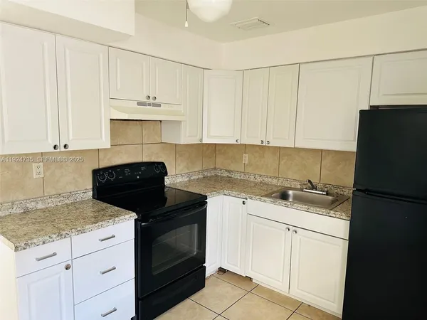a kitchen with a sink and a refrigerator