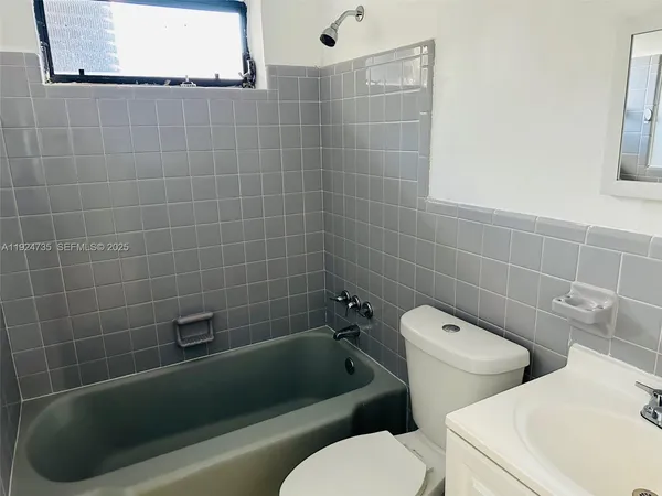 a white toilet sitting next to a bath tub