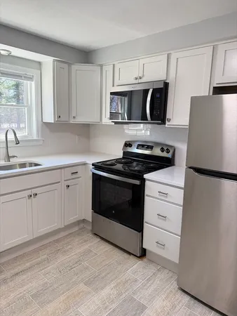a kitchen with white cabinets and stainless steel appliances