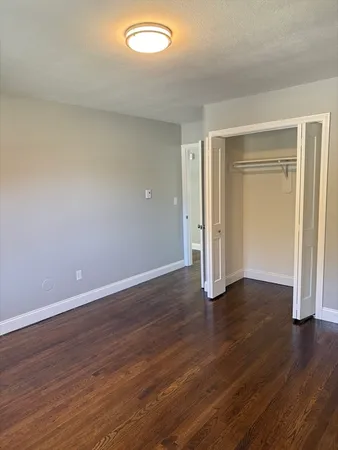 an empty room with wooden floor and closet