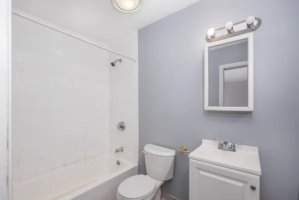 a white toilet sitting next to a bath tub