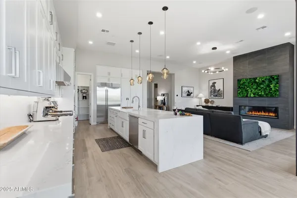 a large kitchen with stainless steel appliances kitchen island a large counter top and a wooden floors