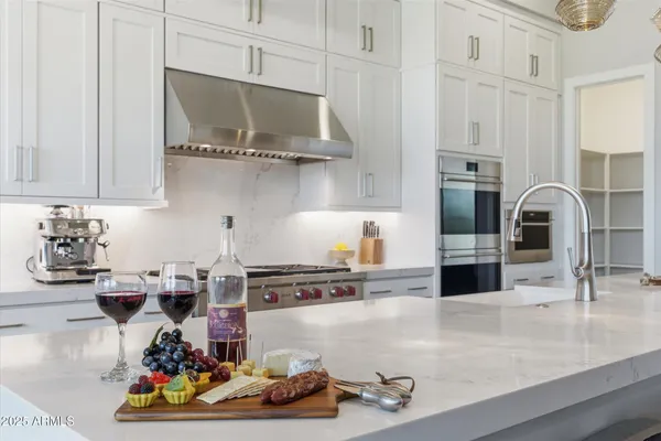 a kitchen with stainless steel appliances kitchen island granite countertop a sink a stove and cabinets