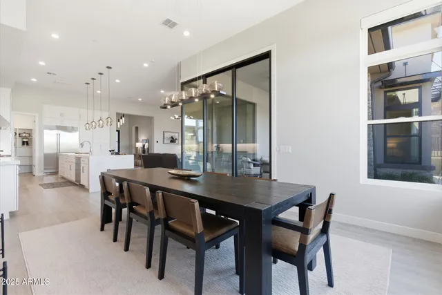 a dining room with stainless steel appliances a table and chairs