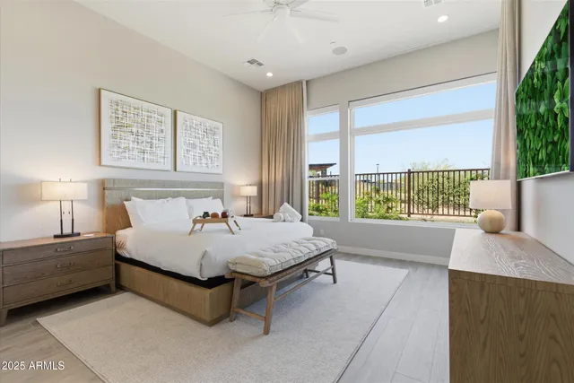 a bed sitting in a spacious bedroom next to a window