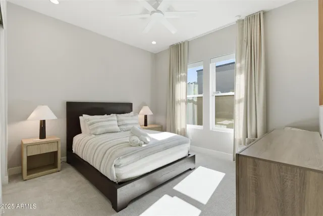 a bedroom with a bed lamp and a large window