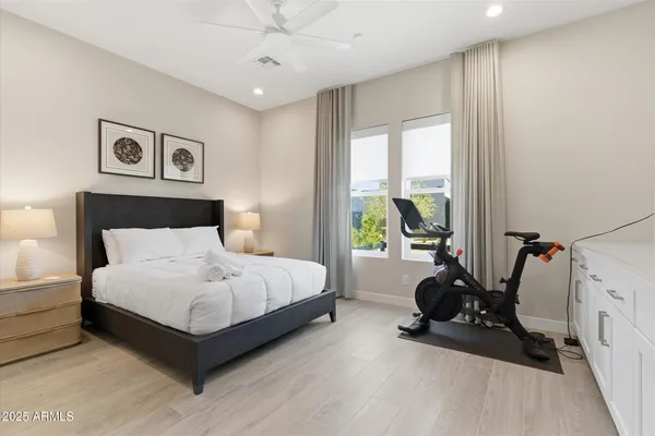 a spacious bedroom with a bed a couch and a large window