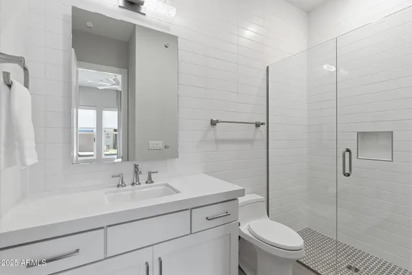 a bathroom with a sink a toilet and shower