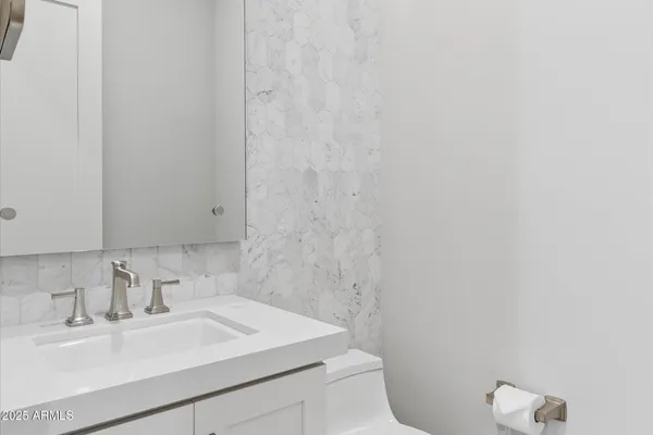 a bathroom with a sink a toilet and mirror