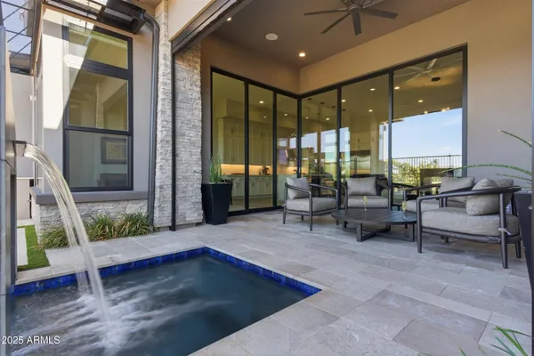 a living room with patio furniture and a large window