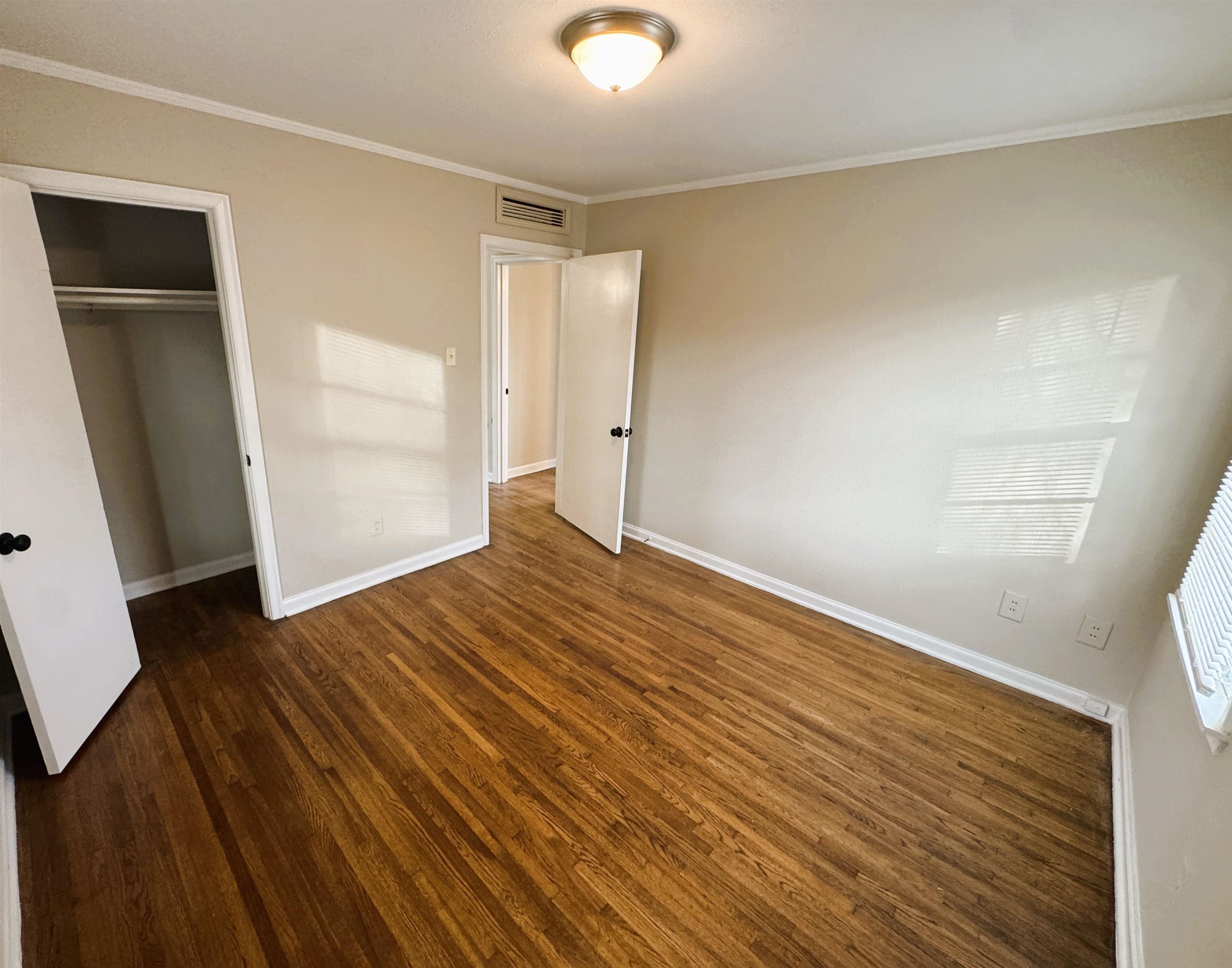 1331 Colonial Road Memphis, TN 38117 - Photo 13 of 18 an empty room with wooden floor and windows
