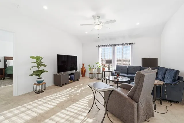 a living room with furniture a window and a flat screen tv
