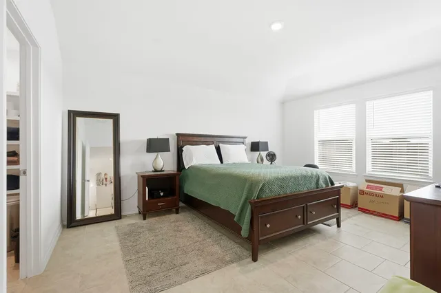 a bedroom with a bed and a large window