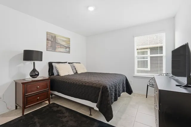 a bedroom with a bed and flat screen tv