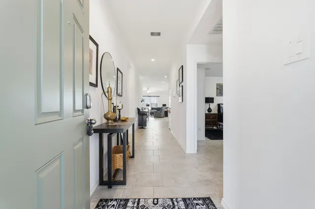 a view of a hallway with wooden floor and a bathroom