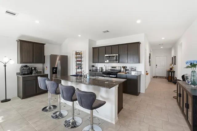 a kitchen with stainless steel appliances kitchen island granite countertop a sink and cabinets