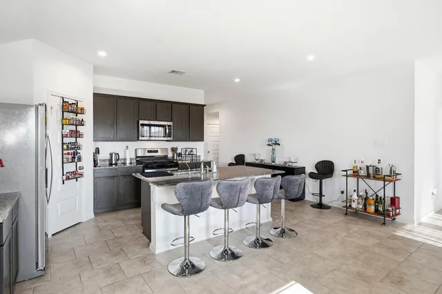 a kitchen with refrigerator and chairs
