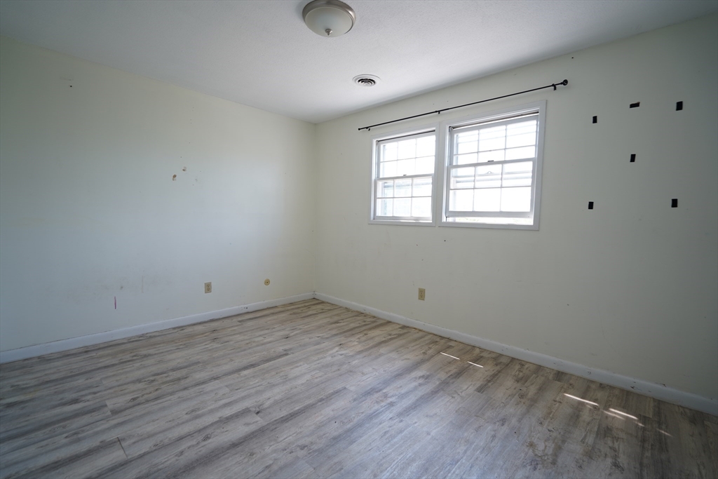 92 Beacon Street, Unit 6 Lawrence, MA 01843 - Photo 12 of 22 an empty room with wooden floor and windows