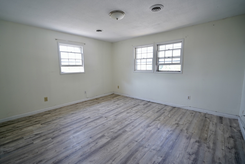 92 Beacon Street, Unit 6 Lawrence, MA 01843 - Photo 10 of 22 an empty room with wooden floor and windows
