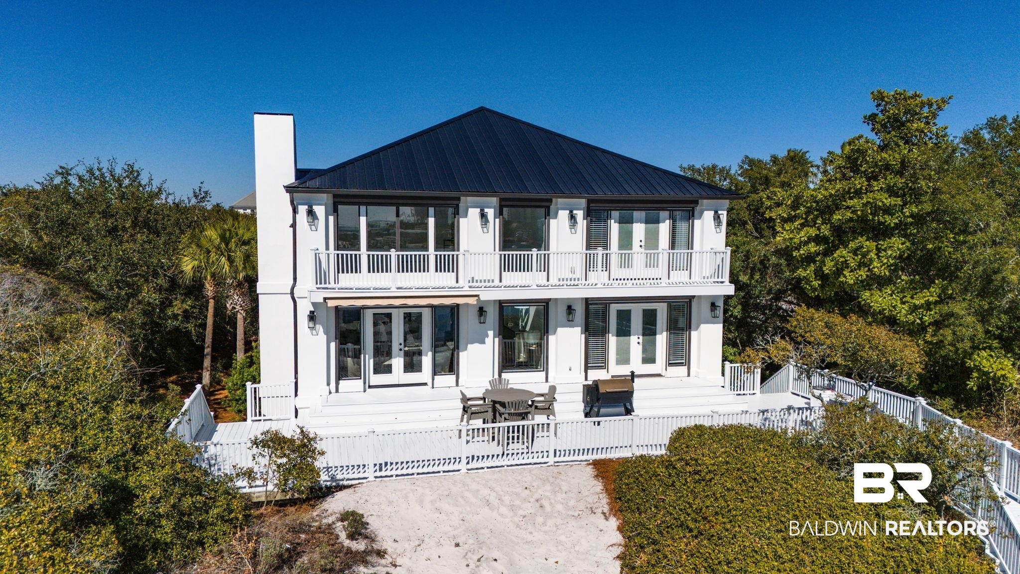 30194 River Road Orange Beach, AL 36561 - Photo 34 of 45 View of front facade featuring french doors, a chimney, a balcony, and a metal roof