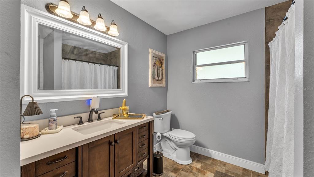 815 West Socrum Loop Road Lakeland, FL 33809 - Photo 27 of 41 a bathroom with a sink vanity granite toilet and a mirror
